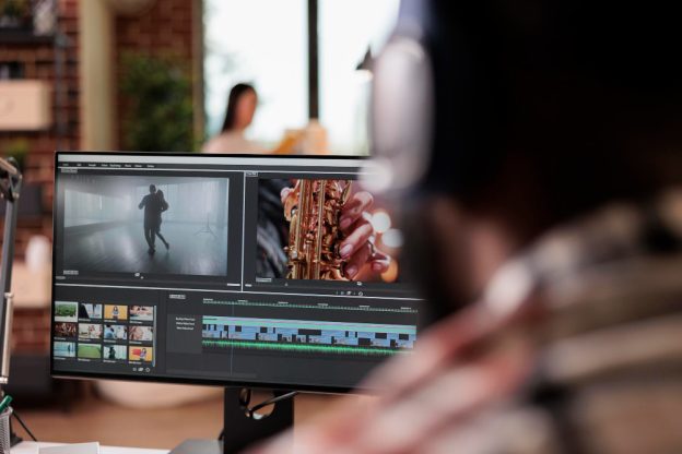 Person editing a video on a computer with a saxophone player and dancer on the screen.